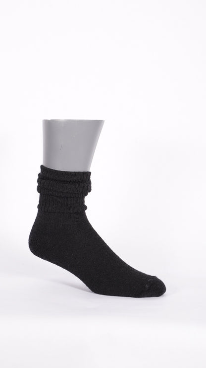 Side profile of a black KnestKnit merino sock showing its gathered ribbed leg and plain-knit foot.