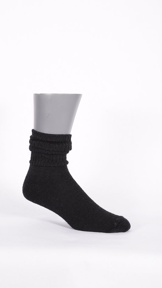 Side profile of a black KnestKnit merino sock showing its gathered ribbed leg and plain-knit foot.