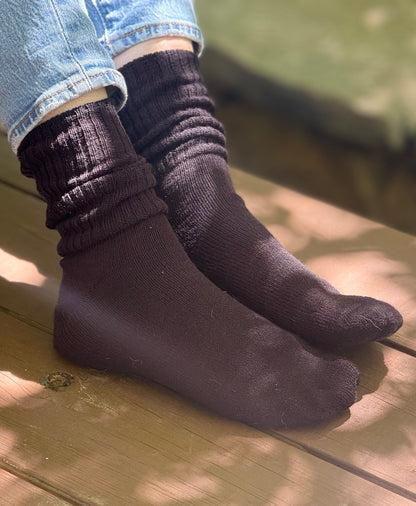 Black KnestKnit rib socks worn with rolled jeans, showing the rib gathered around the ankles.